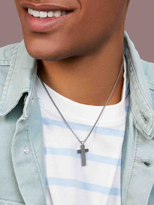 Foto hombre llevando collar de acero con cruz